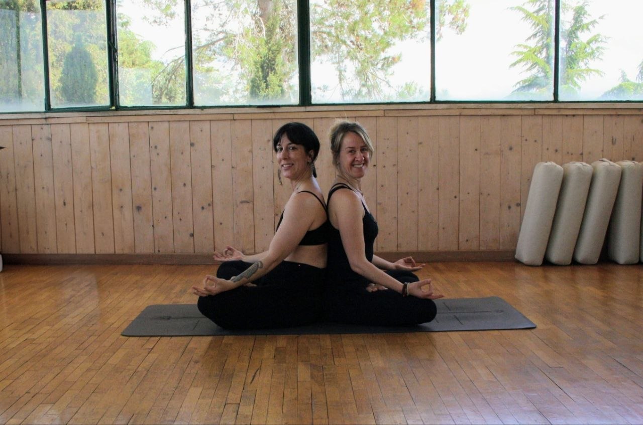Due insegnanti dello studio sedute in posizione meditativa